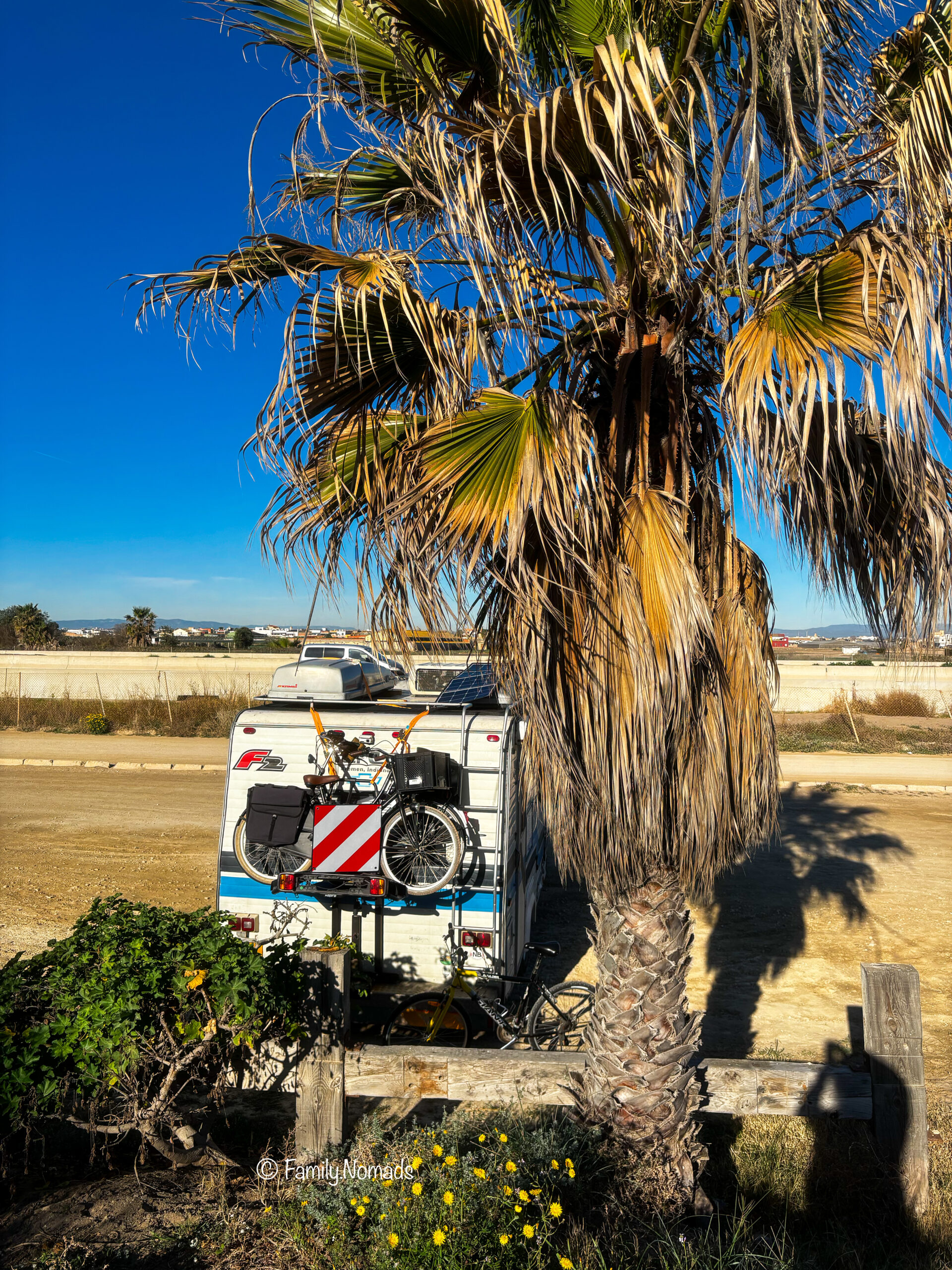 Family Nomads Camper am Strand mit Fahrrädern am Heck